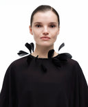 Goose feather collar by MOSAÏKA front view worn on model framing the neckline with light movement and volume