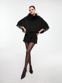 Black silk cape set by MOSAÏKA worn on model with feather statement straps